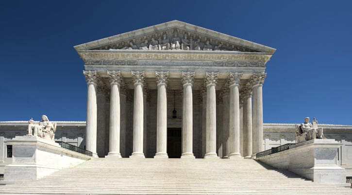Front exterior shot of the US Supreme Court under blue skies