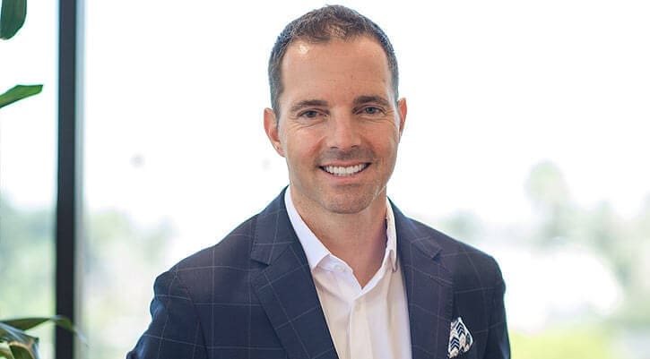 PenChecks Trust Spiro Preovolos President and CEO smiling in front of an office window